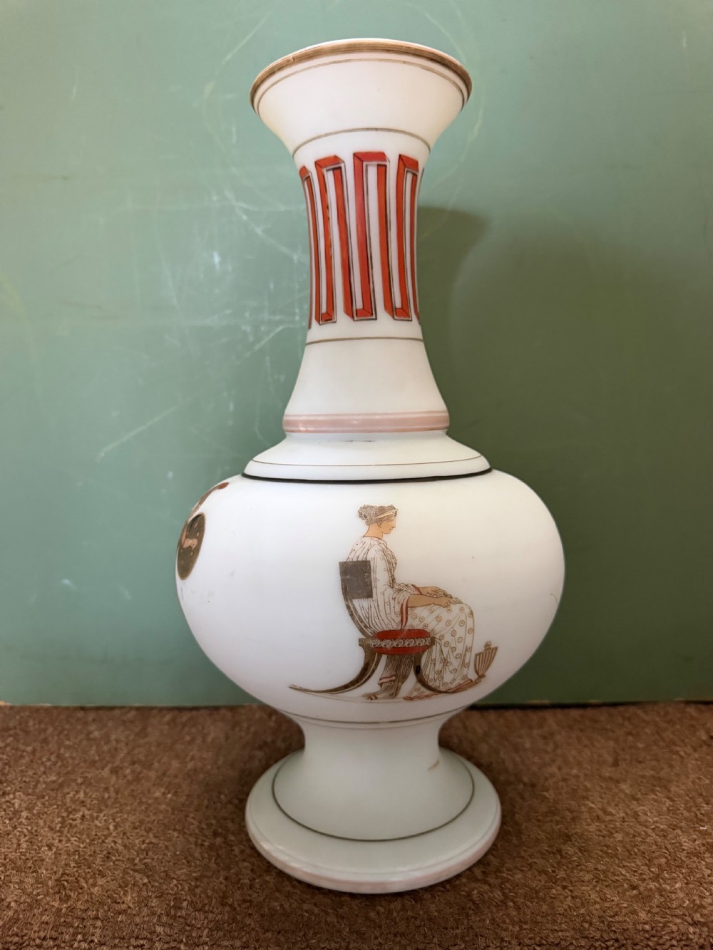 A pair of white opaline glass vases featuring flared necks decorated with orange Greek key patterns and baluster bodies painted with classical Grecian warrior figures. View X