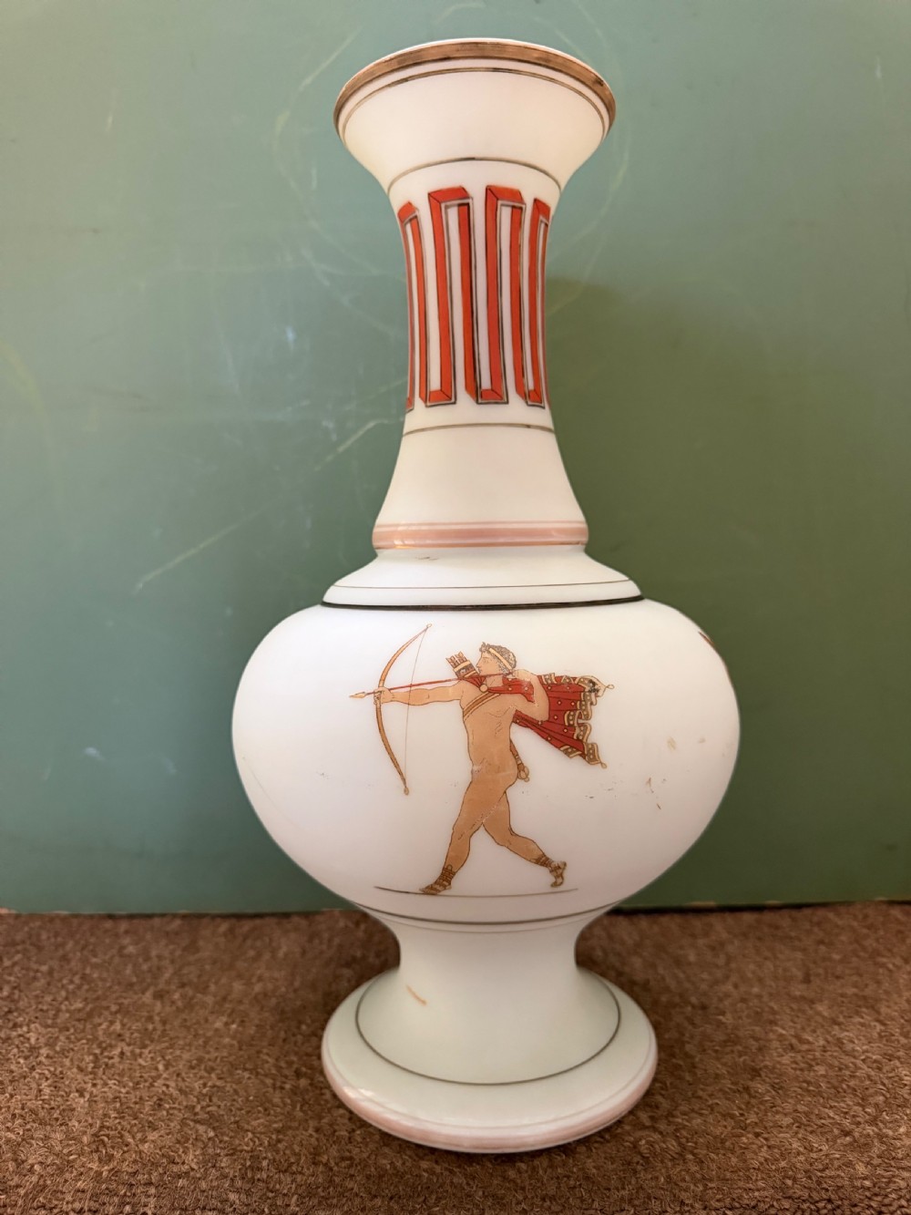 A pair of white opaline glass vases featuring flared necks decorated with orange Greek key patterns and baluster bodies painted with classical Grecian warrior figures. View XI