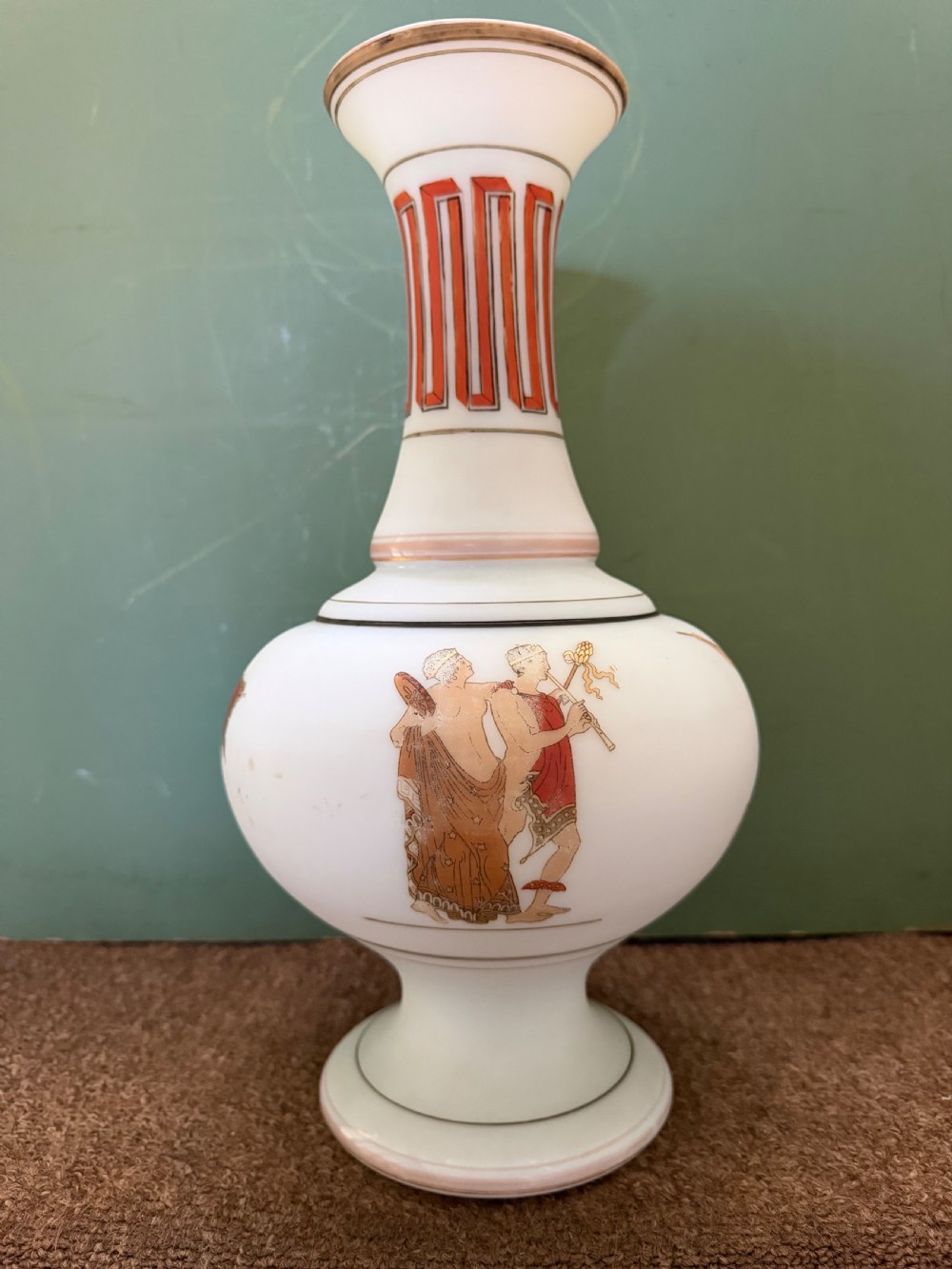 A pair of white opaline glass vases featuring flared necks decorated with orange Greek key patterns and baluster bodies painted with classical Grecian warrior figures. View XII