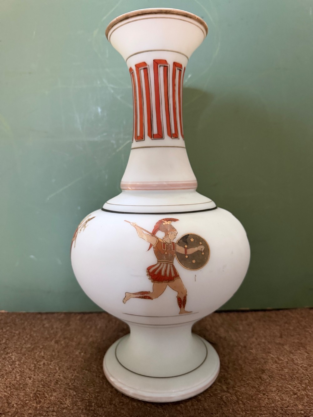 A pair of white opaline glass vases featuring flared necks decorated with orange Greek key patterns and baluster bodies painted with classical Grecian warrior figures. View XIII
