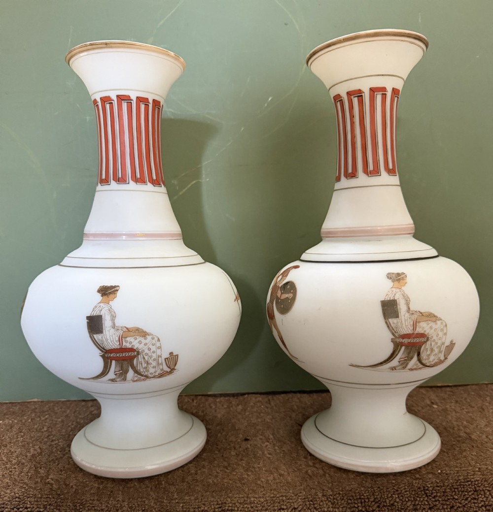 A pair of white opaline glass vases featuring flared necks decorated with orange Greek key patterns and baluster bodies painted with classical Grecian warrior figures. View II