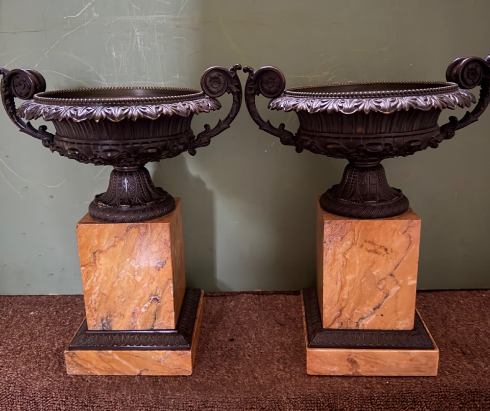A pair of early 19th-century French Charles X dark bronze tazze with scrolling handles set upon yellow Siena marble plinth bases. View II