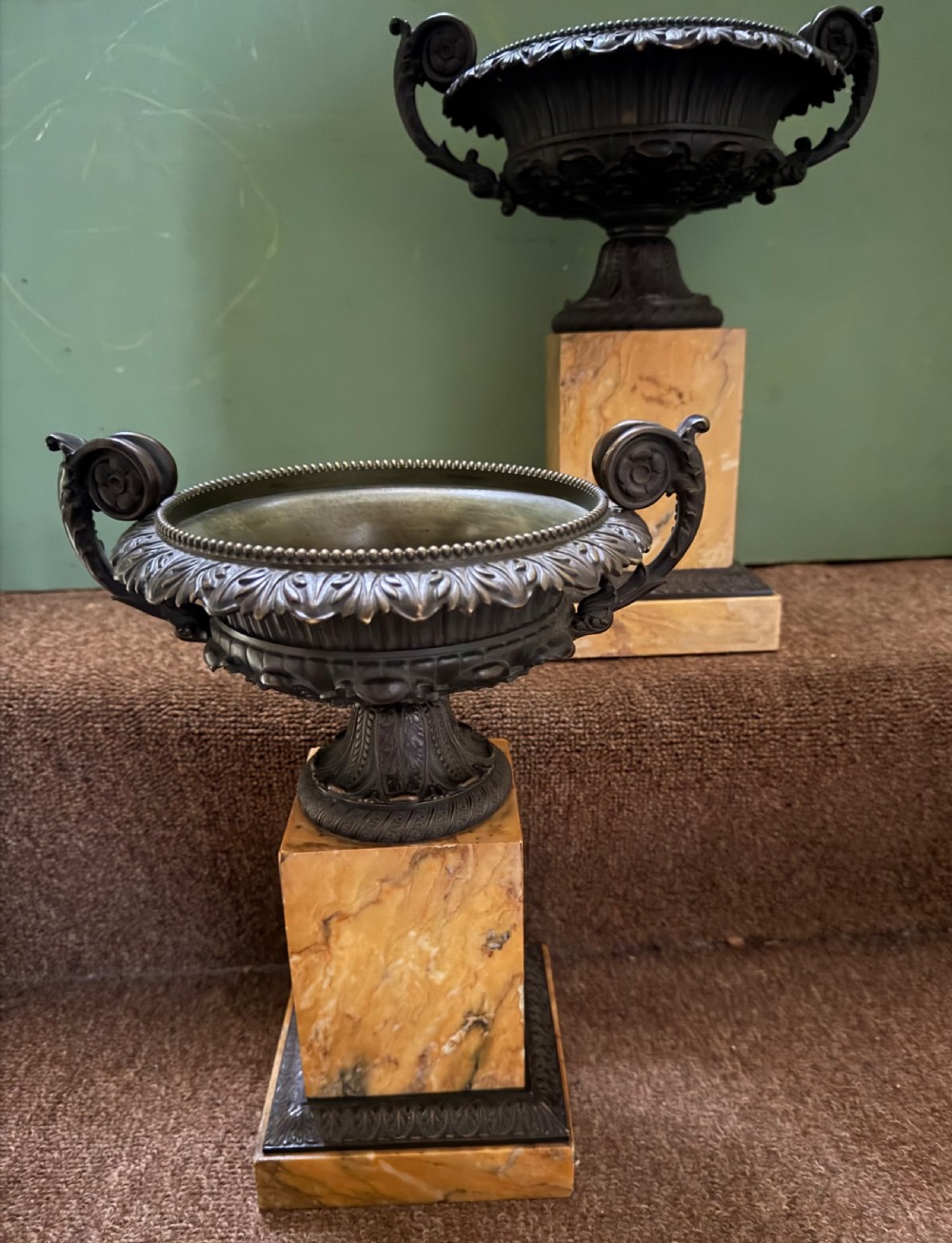 A pair of early 19th-century French Charles X dark bronze tazze with scrolling handles set upon yellow Siena marble plinth bases. View VIII