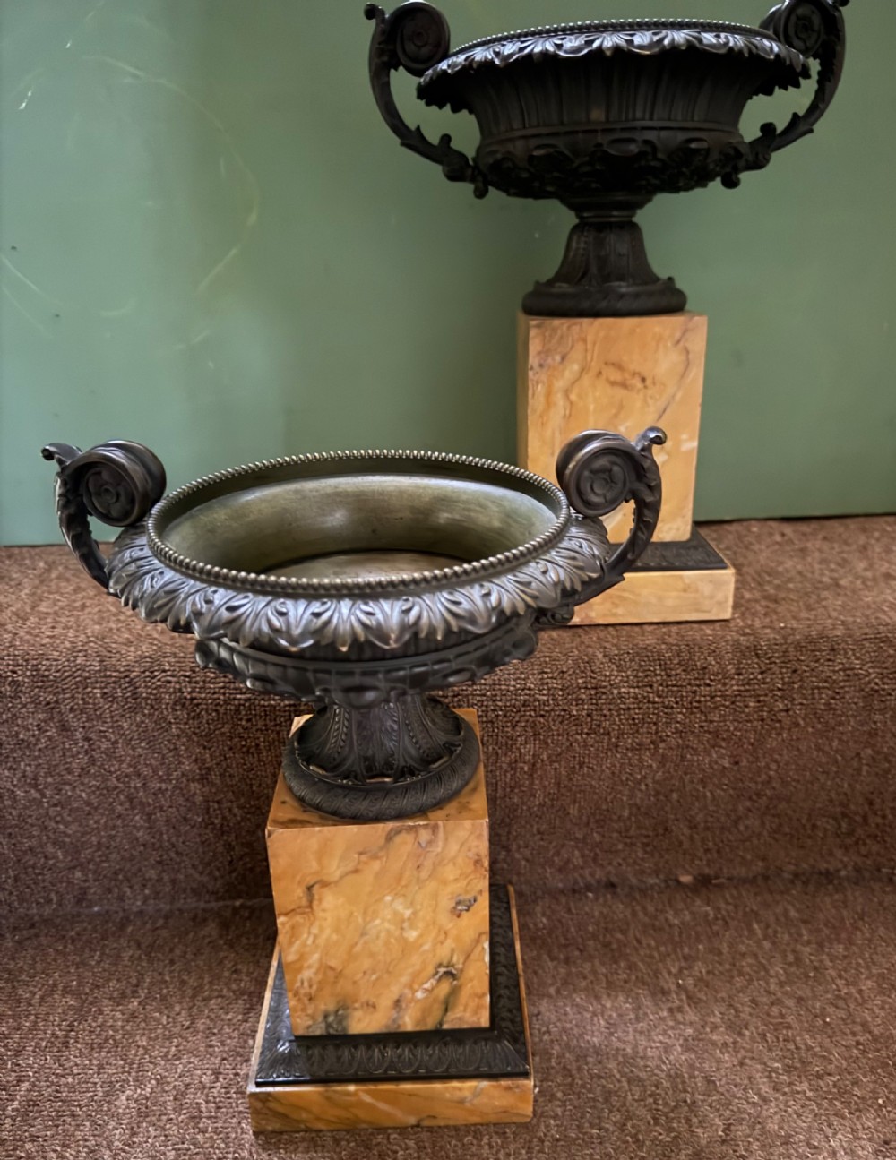 A pair of early 19th-century French Charles X dark bronze tazze with scrolling handles set upon yellow Siena marble plinth bases. View X