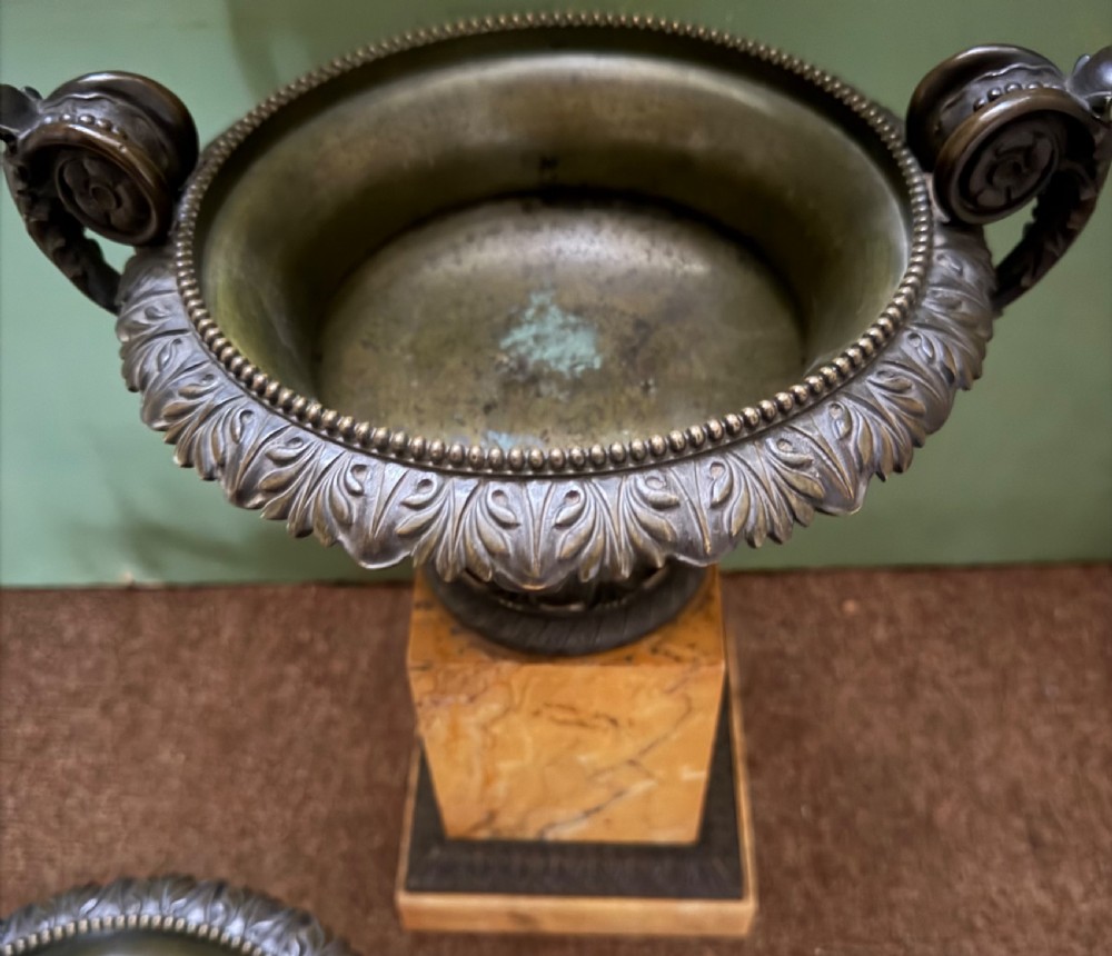 A pair of early 19th-century French Charles X dark bronze tazze with scrolling handles set upon yellow Siena marble plinth bases. View XIII
