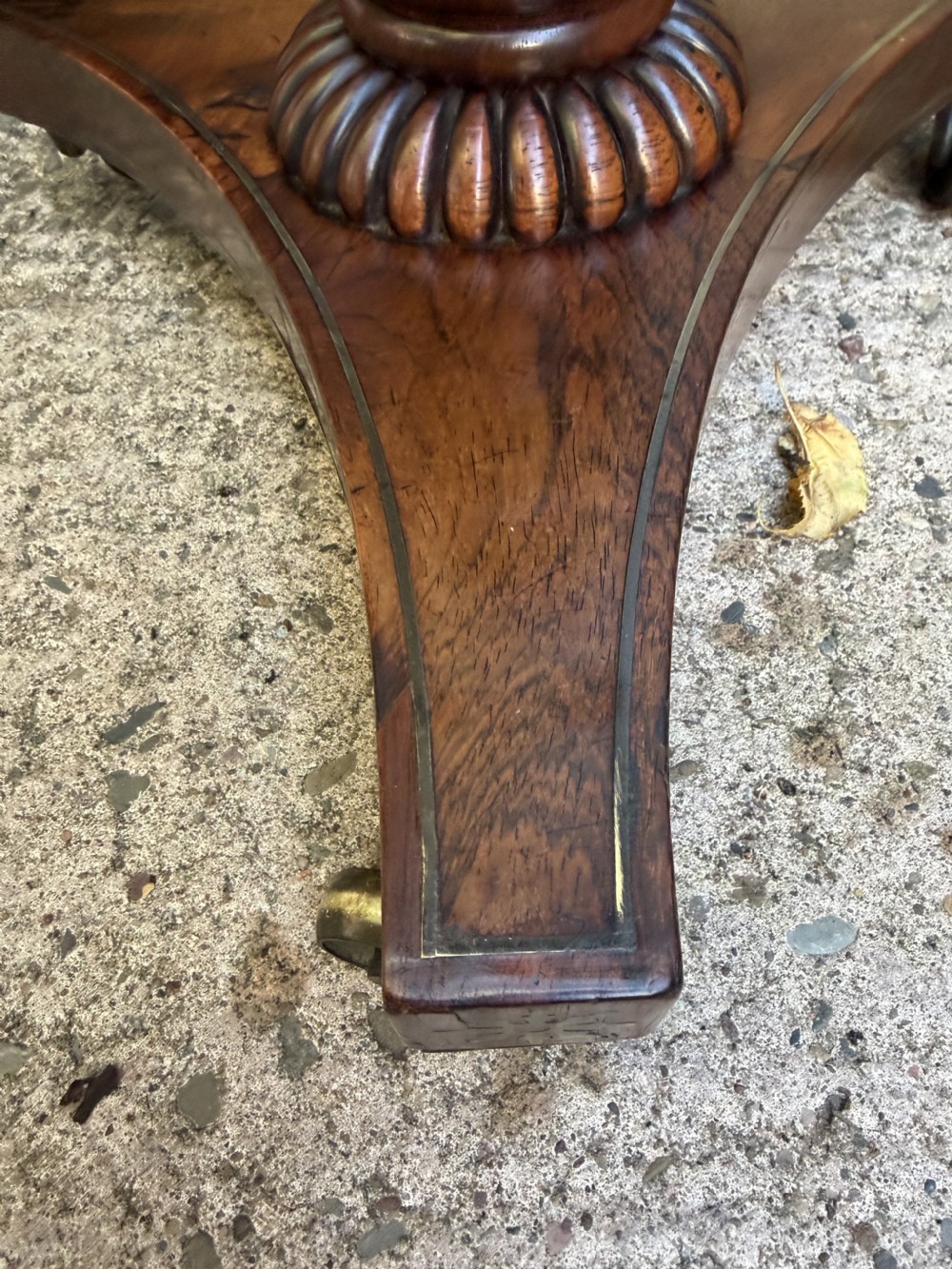 An early 19th-century Regency rosewood duet music stand featuring an adjustable double-sided frame with cross-latticed supports, twin brass candle sconces, a fluted column, and a tripartite base on castors. View IX