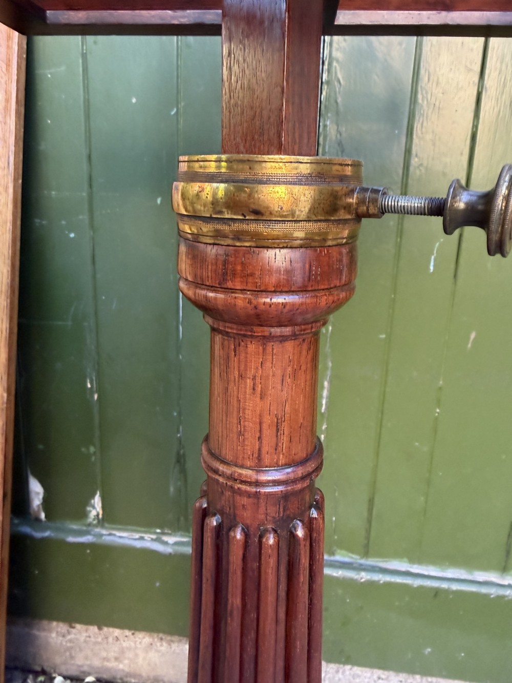 An early 19th-century Regency rosewood duet music stand featuring an adjustable double-sided frame with cross-latticed supports, twin brass candle sconces, a fluted column, and a tripartite base on castors. View XI