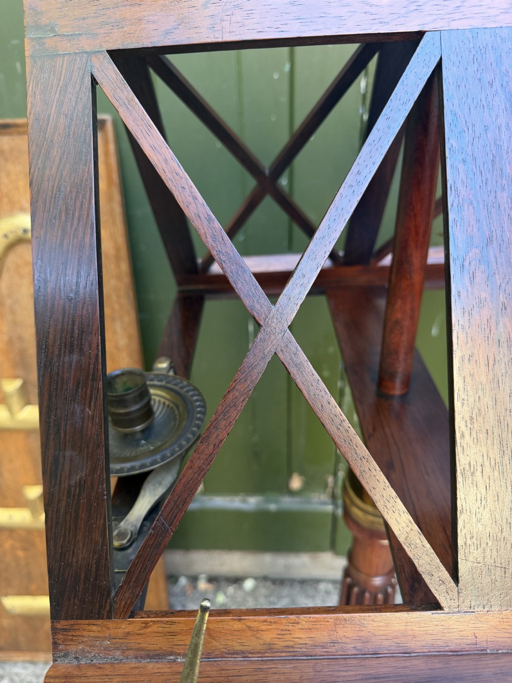 An early 19th-century Regency rosewood duet music stand featuring an adjustable double-sided frame with cross-latticed supports, twin brass candle sconces, a fluted column, and a tripartite base on castors. View XIV