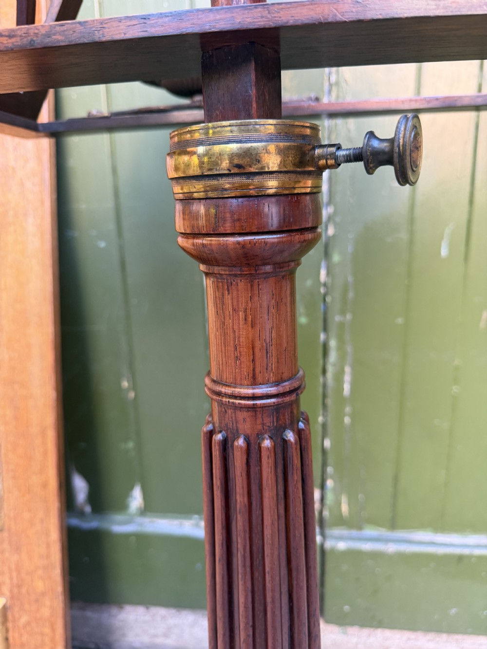 An early 19th-century Regency rosewood duet music stand featuring an adjustable double-sided frame with cross-latticed supports, twin brass candle sconces, a fluted column, and a tripartite base on castors. View XVII