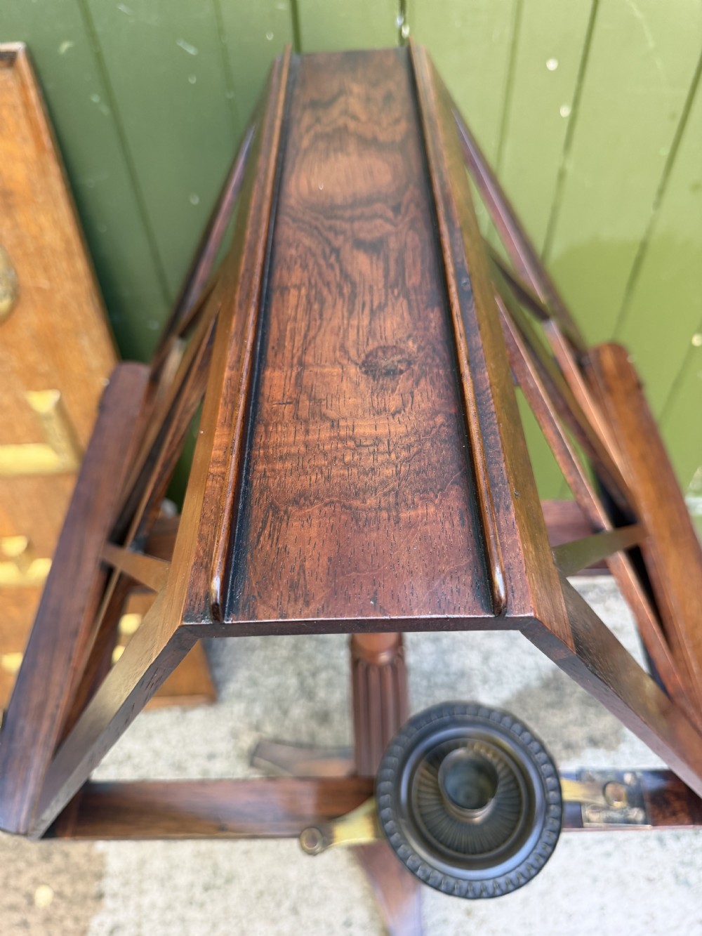 An early 19th-century Regency rosewood duet music stand featuring an adjustable double-sided frame with cross-latticed supports, twin brass candle sconces, a fluted column, and a tripartite base on castors. View XIX