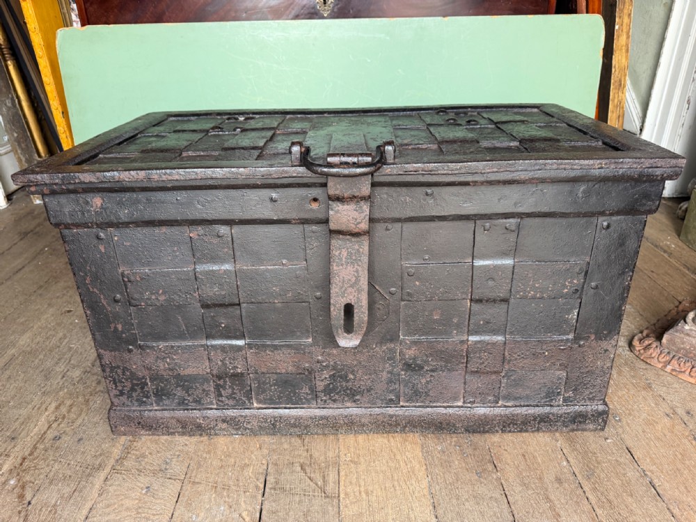A rectangular late seventeenth-century wrought iron strongbox with criss-crossing riveted bands and a heavy central iron locking hasp. View II