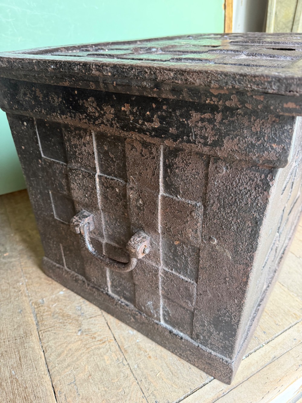 A rectangular late seventeenth-century wrought iron strongbox with criss-crossing riveted bands and a heavy central iron locking hasp. View V