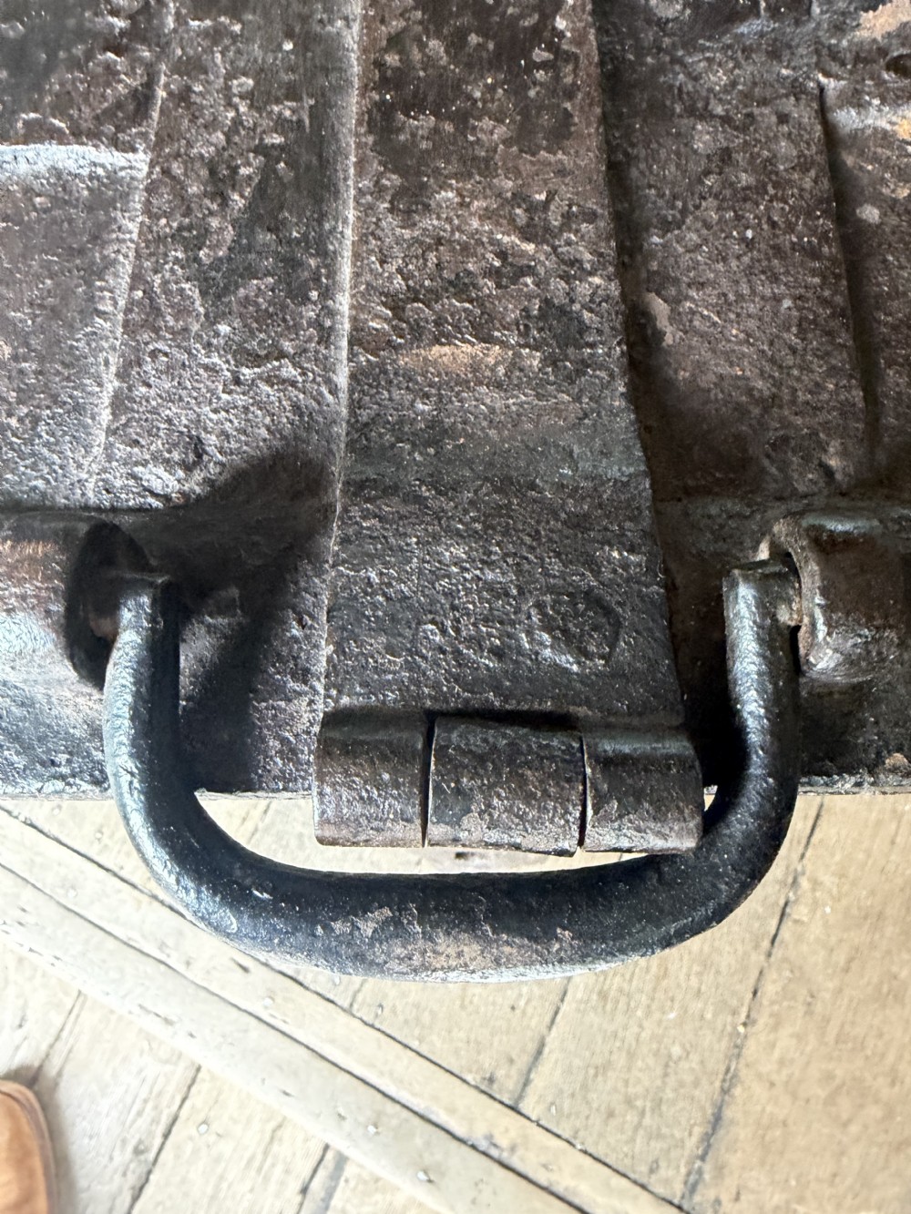 A rectangular late seventeenth-century wrought iron strongbox with criss-crossing riveted bands and a heavy central iron locking hasp. View VII