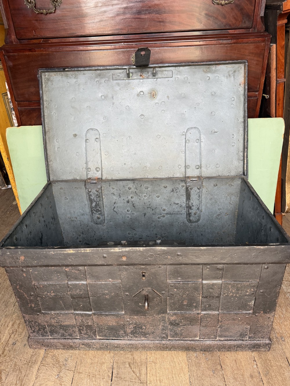 A rectangular late seventeenth-century wrought iron strongbox with criss-crossing riveted bands and a heavy central iron locking hasp. View X