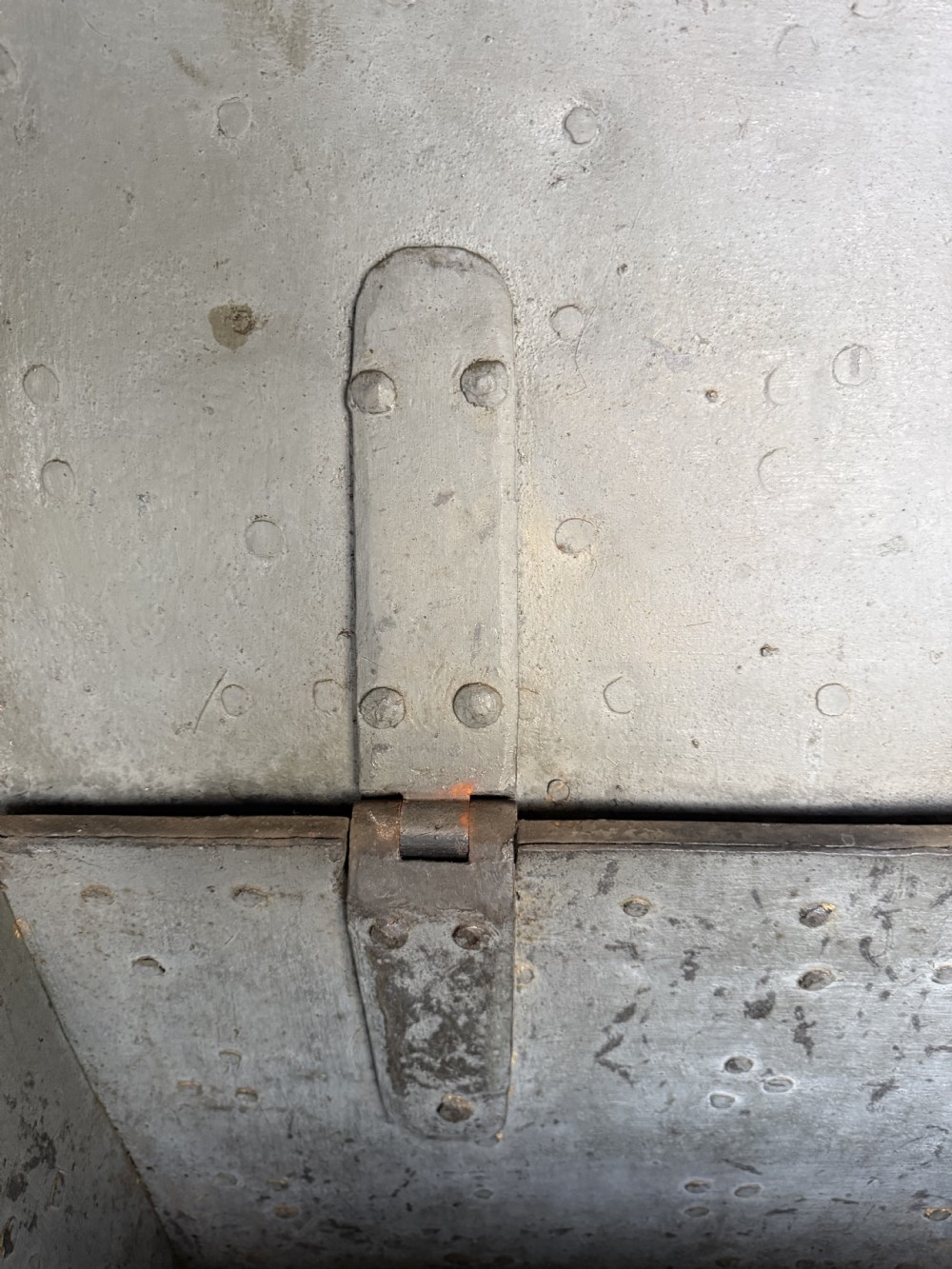 A rectangular late seventeenth-century wrought iron strongbox with criss-crossing riveted bands and a heavy central iron locking hasp. View XI