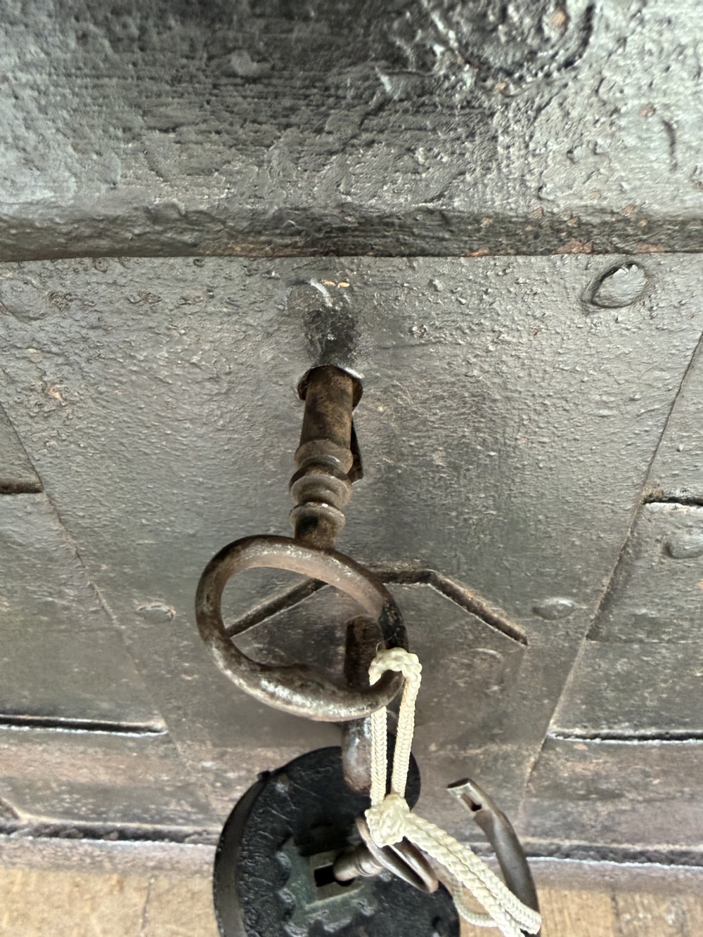 A rectangular late seventeenth-century wrought iron strongbox with criss-crossing riveted bands and a heavy central iron locking hasp. View XIII