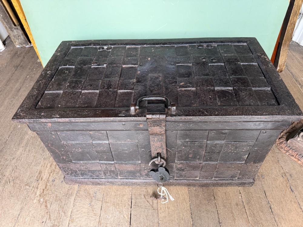 A rectangular late seventeenth-century wrought iron strongbox with criss-crossing riveted bands and a heavy central iron locking hasp. View XIV