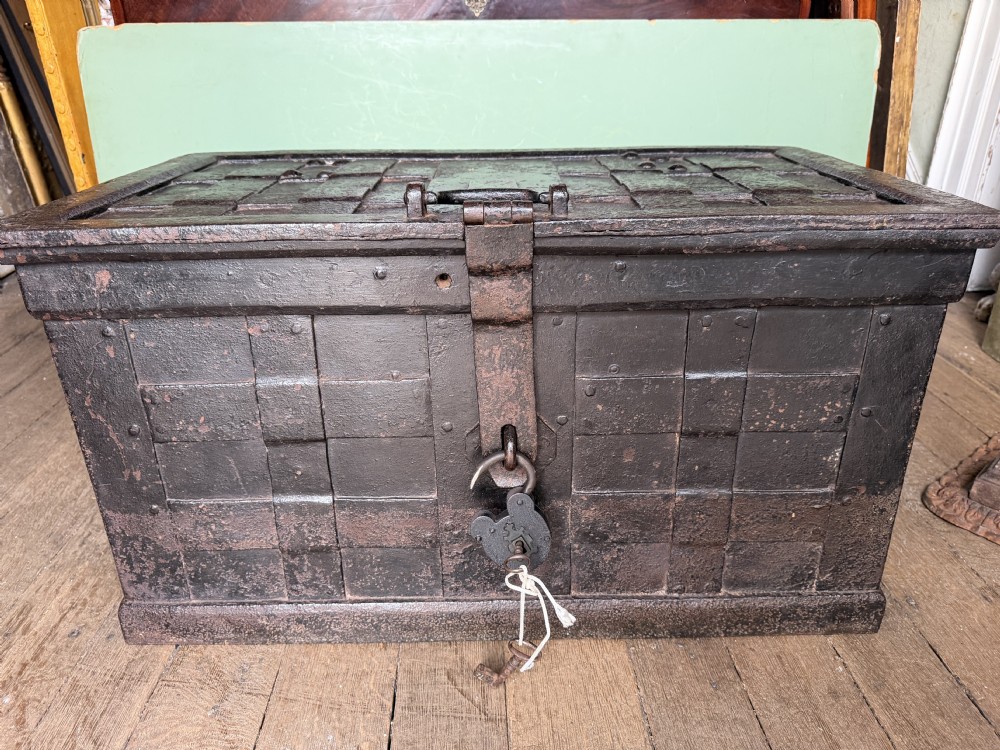 A rectangular late seventeenth-century wrought iron strongbox with criss-crossing riveted bands and a heavy central iron locking hasp. View XV