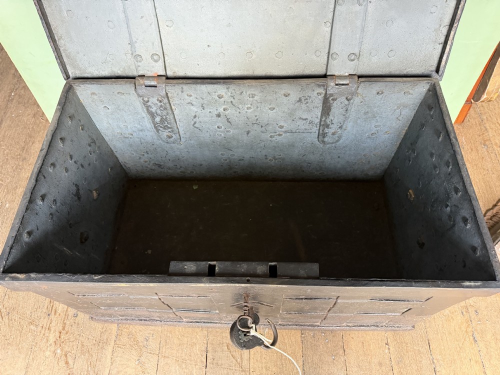 A rectangular late seventeenth-century wrought iron strongbox with criss-crossing riveted bands and a heavy central iron locking hasp. View XVII