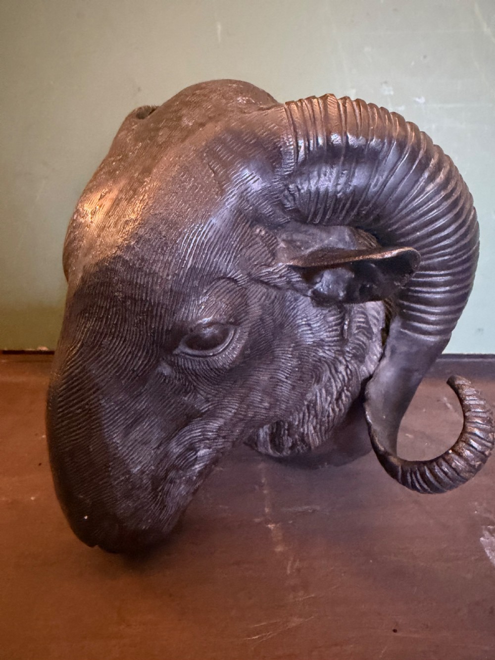 A late 19th-century cast bronze study featuring a ram head with detailed spiralled horns and textured fleece.