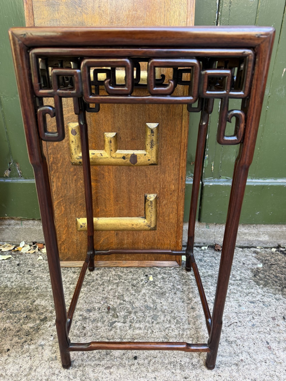 A set of three graduated dark hardwood Chinese nesting tables featuring openwork carved fretwork aprons and straight legs with perimeter stretchers. View XII