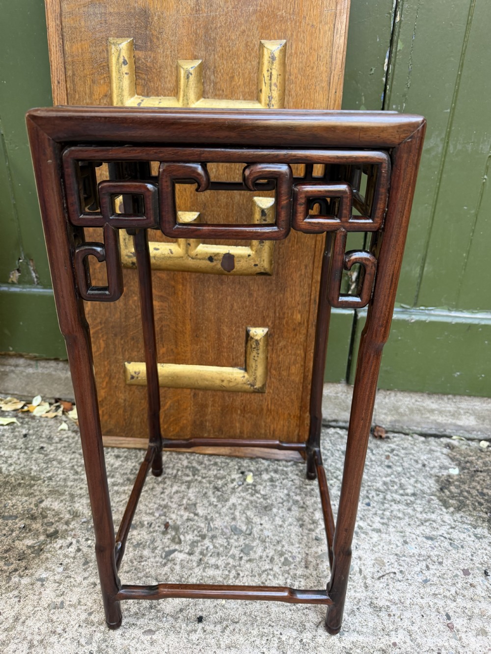 A set of three graduated dark hardwood Chinese nesting tables featuring openwork carved fretwork aprons and straight legs with perimeter stretchers. View XIII