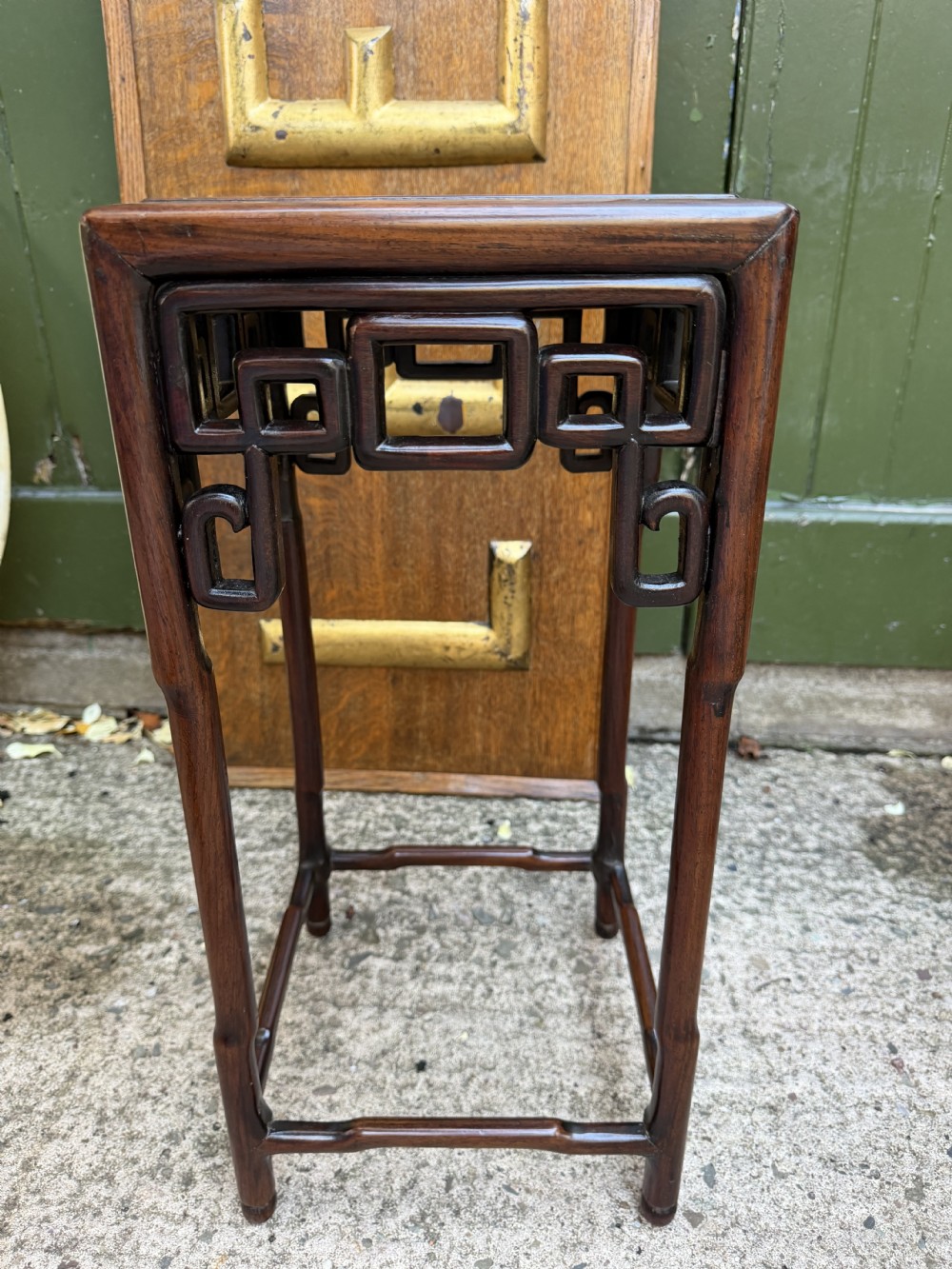 A set of three graduated dark hardwood Chinese nesting tables featuring openwork carved fretwork aprons and straight legs with perimeter stretchers. View XIV