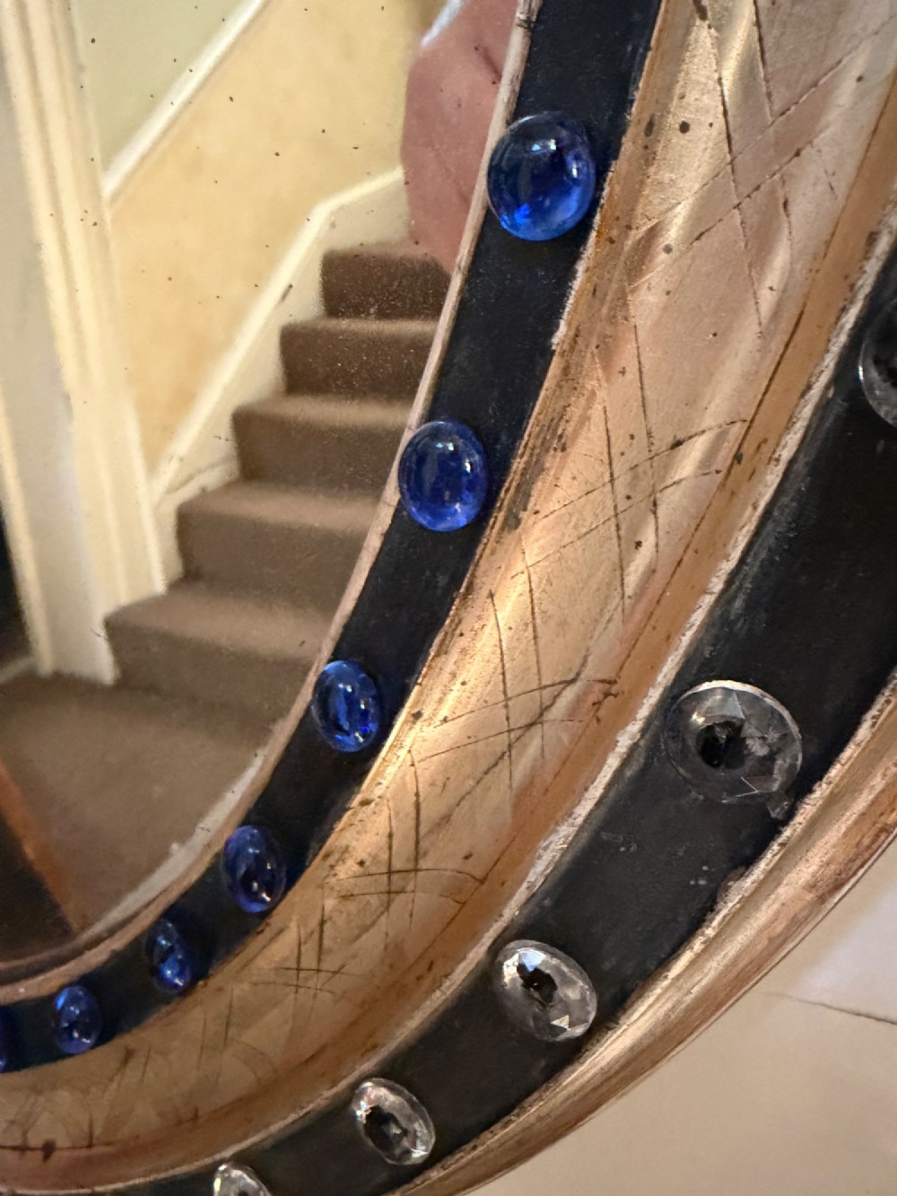 A nineteenth-century Irish oval wall mirror featuring an ebonised frame inset with clear facetted glass jewels, an inner silver-gilt band, and cobalt blue glass cabochons. View III