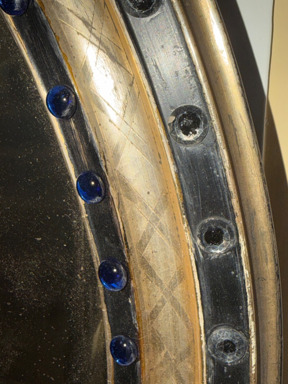 A nineteenth-century Irish oval wall mirror featuring an ebonised frame inset with clear facetted glass jewels, an inner silver-gilt band, and cobalt blue glass cabochons. View IX