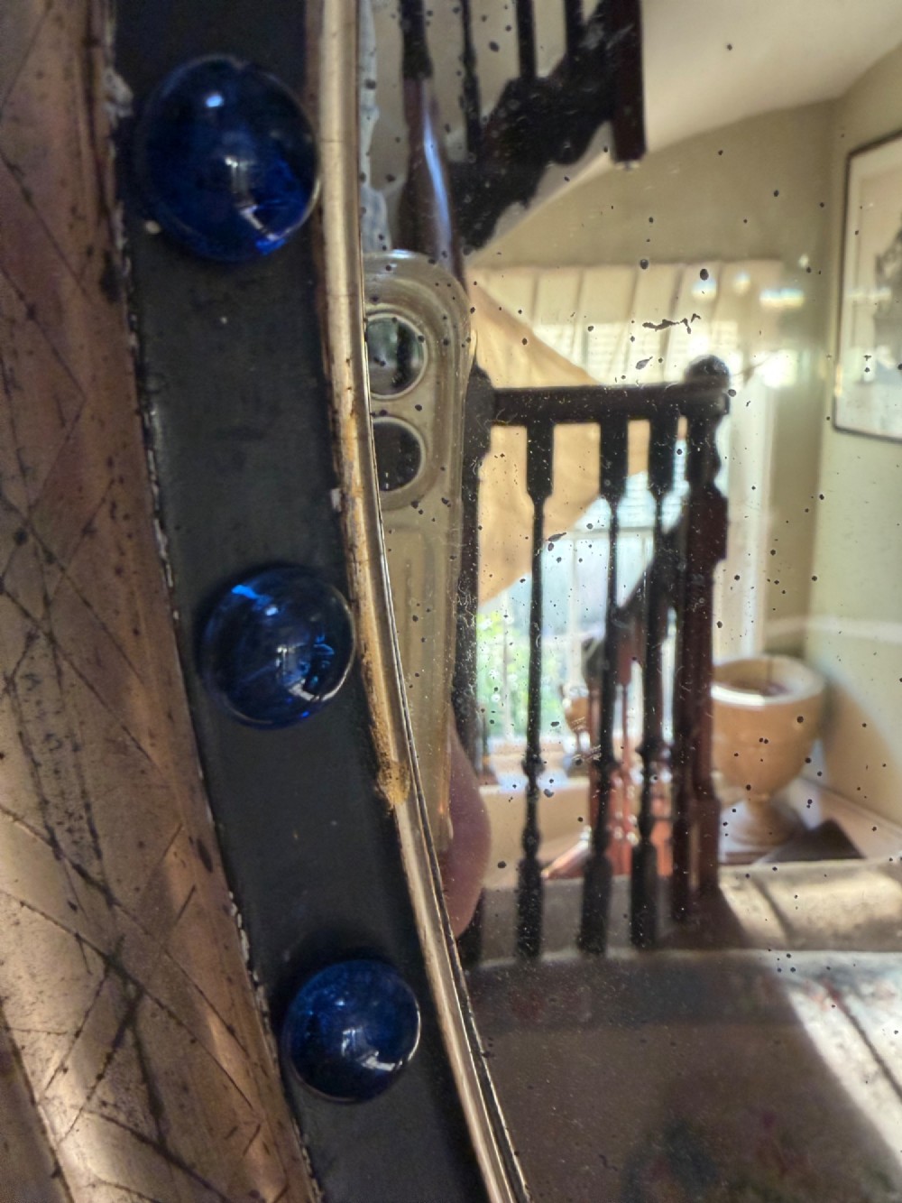 A nineteenth-century Irish oval wall mirror featuring an ebonised frame inset with clear facetted glass jewels, an inner silver-gilt band, and cobalt blue glass cabochons. View XI