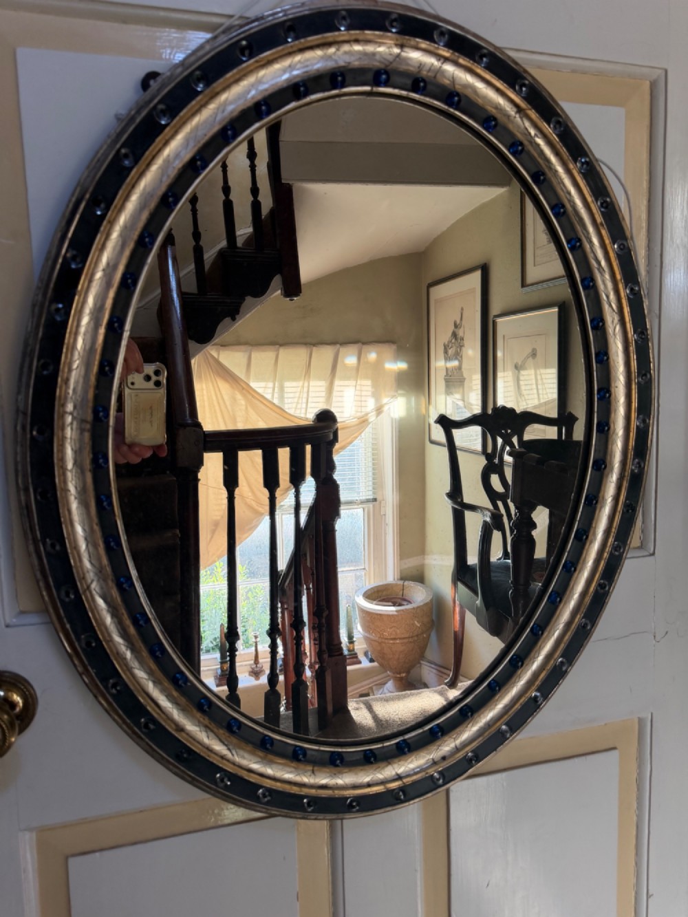 A nineteenth-century Irish oval wall mirror featuring an ebonised frame inset with clear facetted glass jewels, an inner silver-gilt band, and cobalt blue glass cabochons. View XII