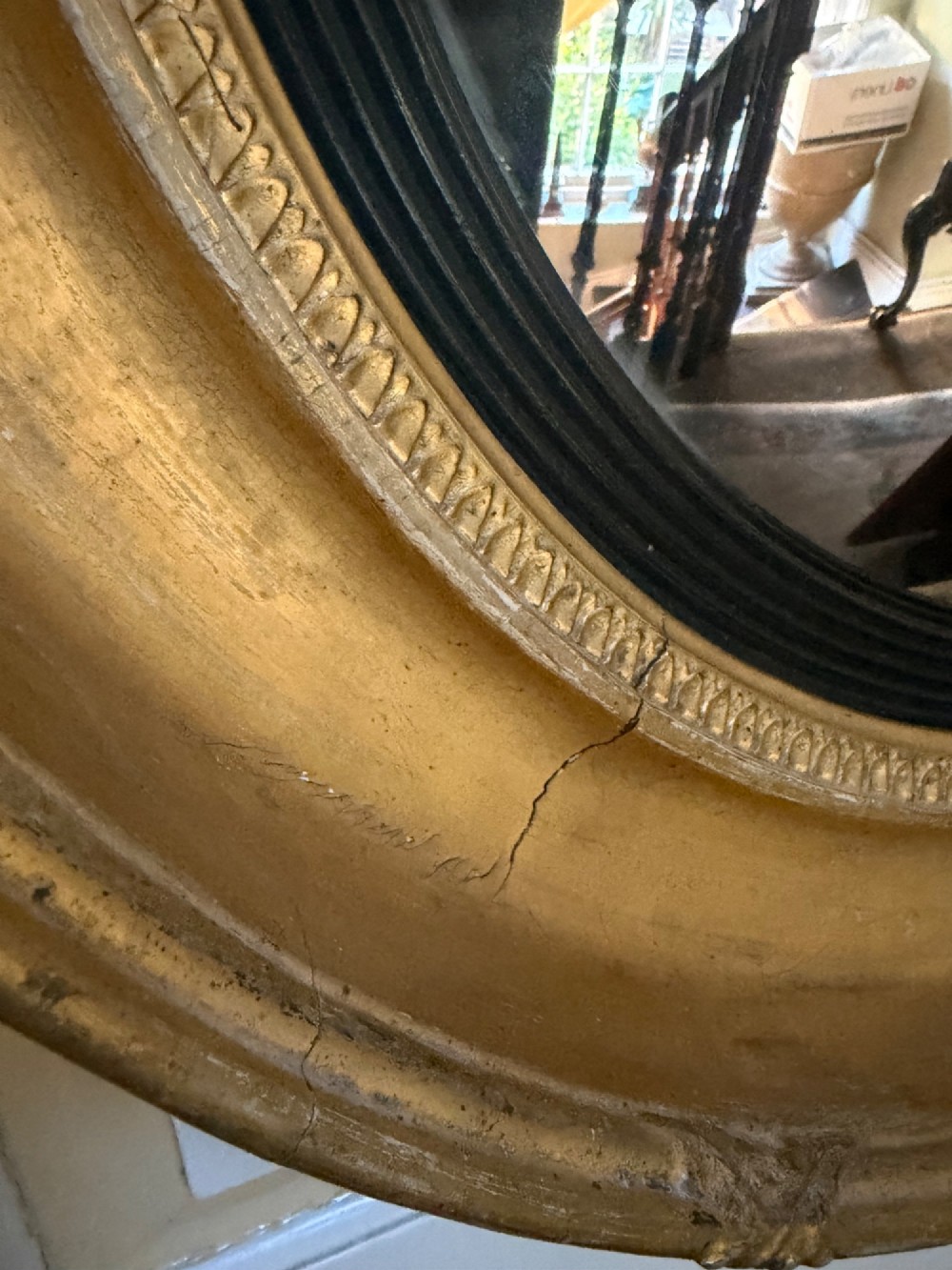 A circular early 19th-century Regency convex mirror featuring a gilded carved frame with an ebonised inner reeded slip. View VII