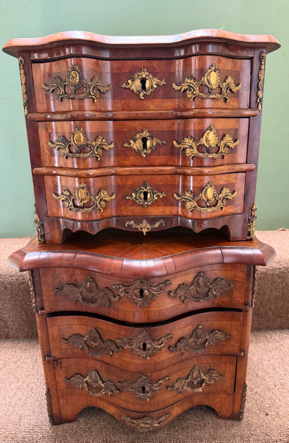 A matched pair of late nineteenth-century French miniature walnut commodes featuring serpentine three-drawer fronts and cast gilt-bronze mounts. View VII