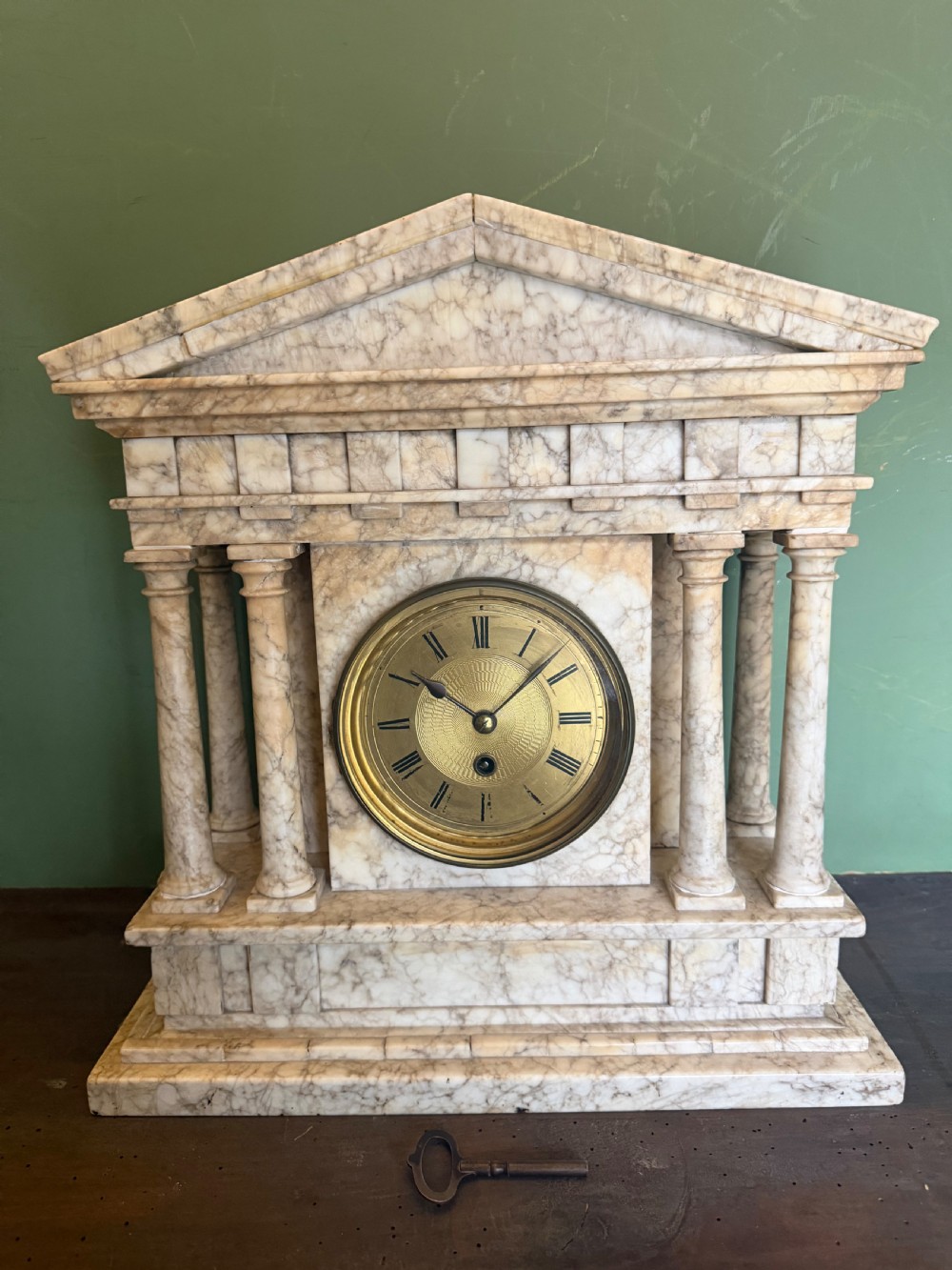 A late nineteenth-century carved cream alabaster mantel clock styled as a classical Greek temple with columns and a central brass dial. View III