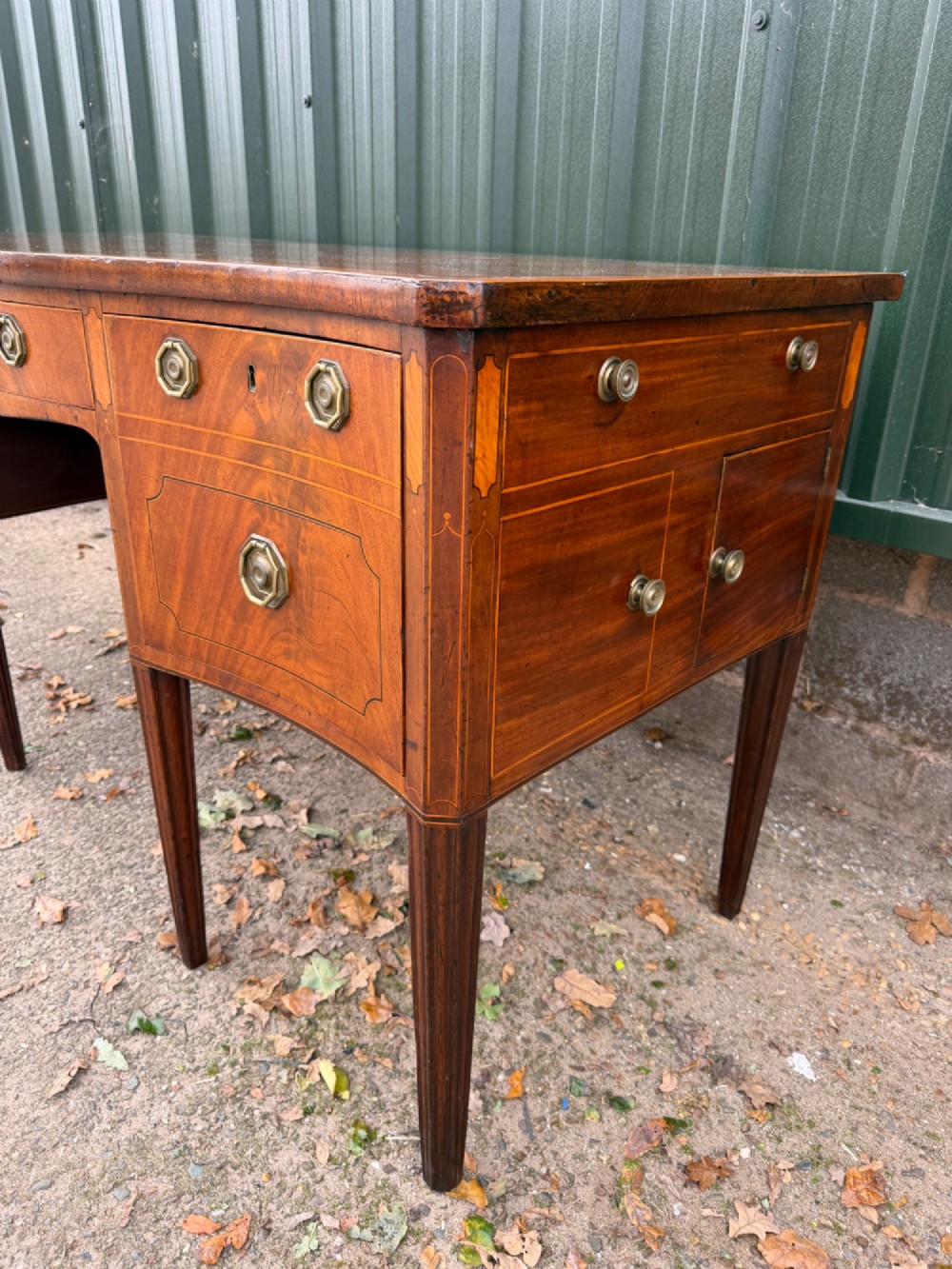 A late 18th-century George III mahogany sideboard featuring a serpentine front, stringing inlays, brass octagonal handles, and tapered square legs. View III