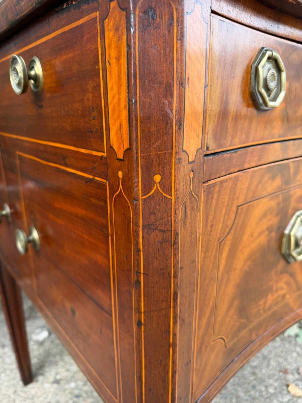 A late 18th-century George III mahogany sideboard featuring a serpentine front, stringing inlays, brass octagonal handles, and tapered square legs. View IV
