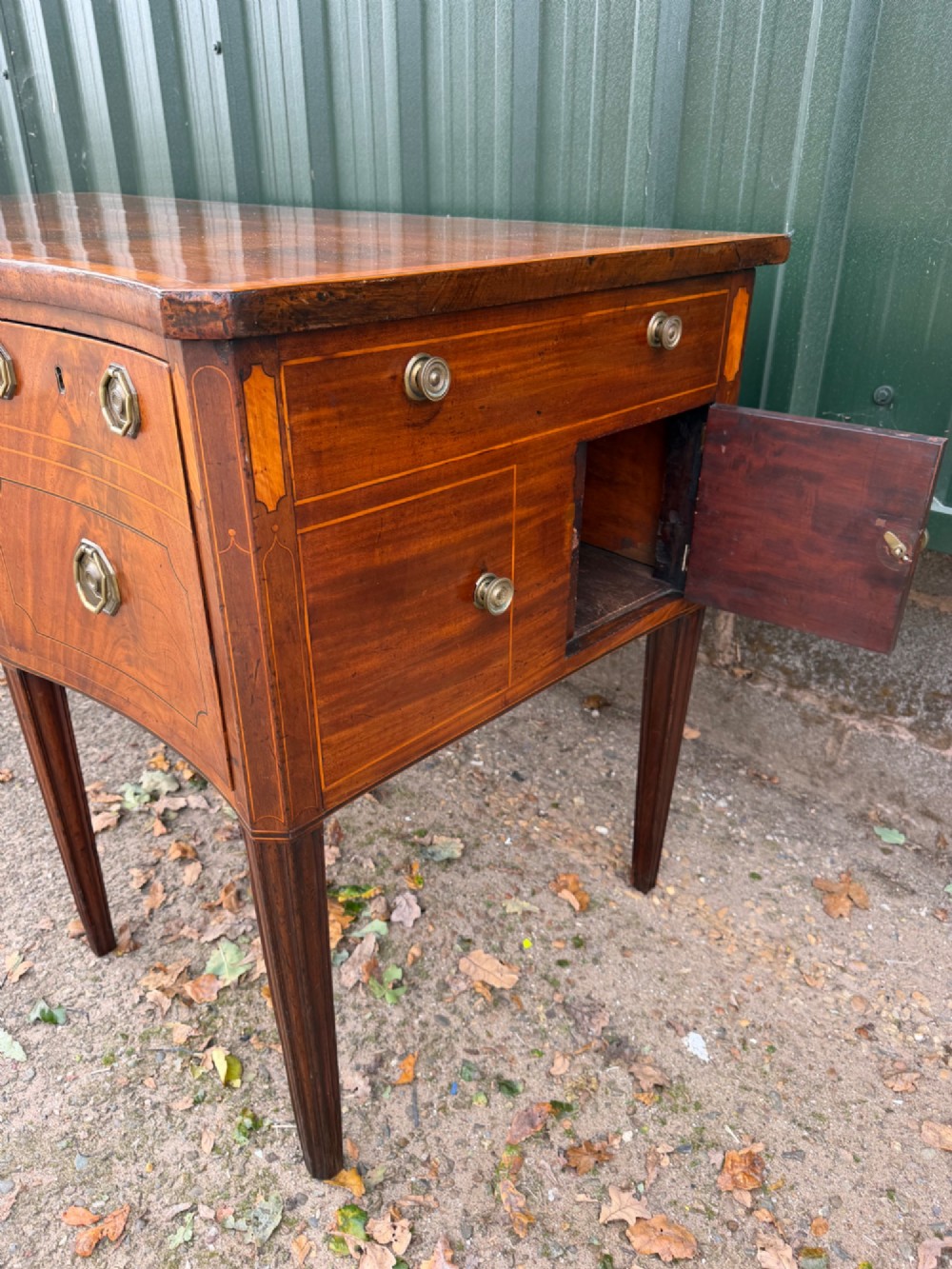 A late 18th-century George III mahogany sideboard featuring a serpentine front, stringing inlays, brass octagonal handles, and tapered square legs. View IX