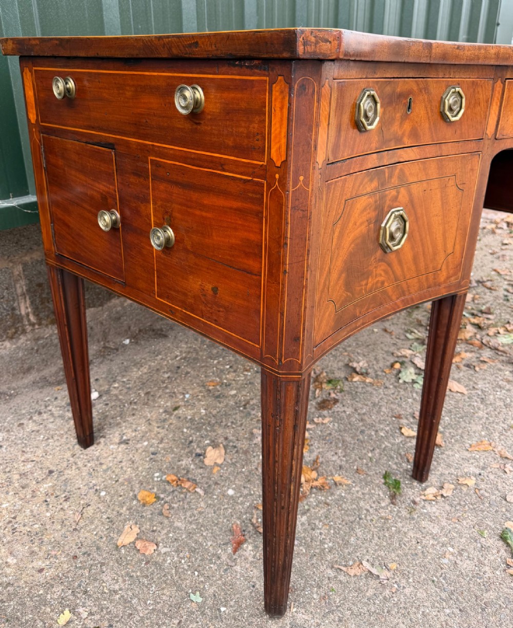 A late 18th-century George III mahogany sideboard featuring a serpentine front, stringing inlays, brass octagonal handles, and tapered square legs. View XII