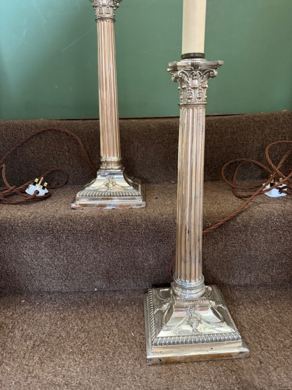 A pair of late nineteenth-century silver-plated table lamps designed as fluted Corinthian columns on square stepped bases with classical swag relief. View VII