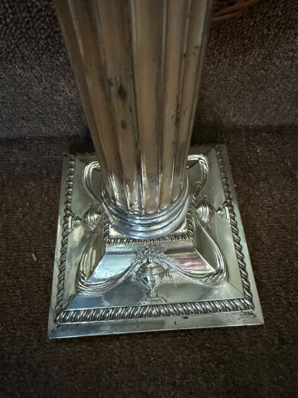 A pair of late nineteenth-century silver-plated table lamps designed as fluted Corinthian columns on square stepped bases with classical swag relief. View XIV