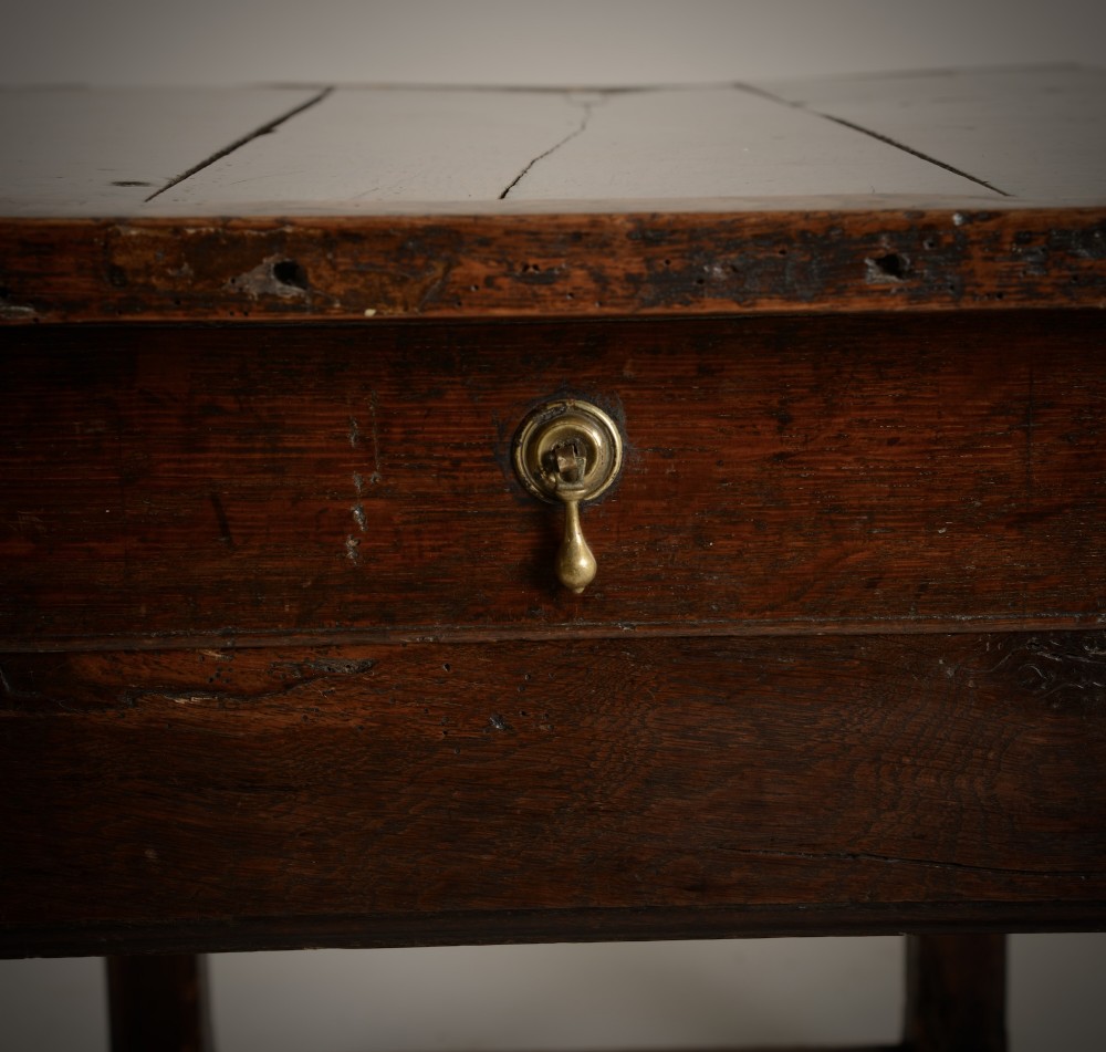 An antique dark oak low table featuring a plank top, a small side drawer with a brass drop handle, and sturdy legs joined by rectangular stretchers. View III
