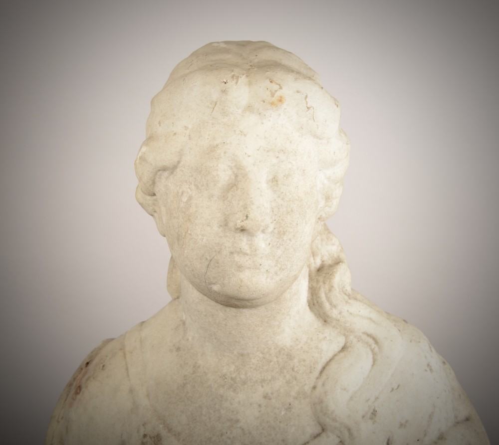 A carved off-white marble bust of a woman with classical draped clothing resting on a painted and gilded wooden pedestal. View II
