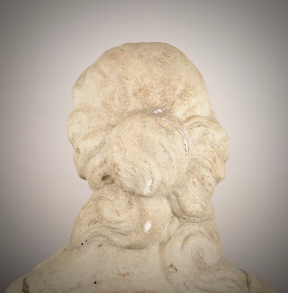 A carved off-white marble bust of a woman with classical draped clothing resting on a painted and gilded wooden pedestal. View VI