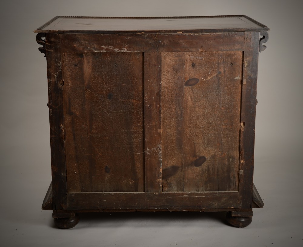 An antique warm brown walnut chest of drawers featuring geometric moulded drawer fronts, brass drop handles, and turned bun feet. View VIII