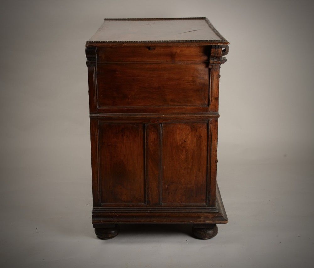 An antique warm brown walnut chest of drawers featuring geometric moulded drawer fronts, brass drop handles, and turned bun feet. View X