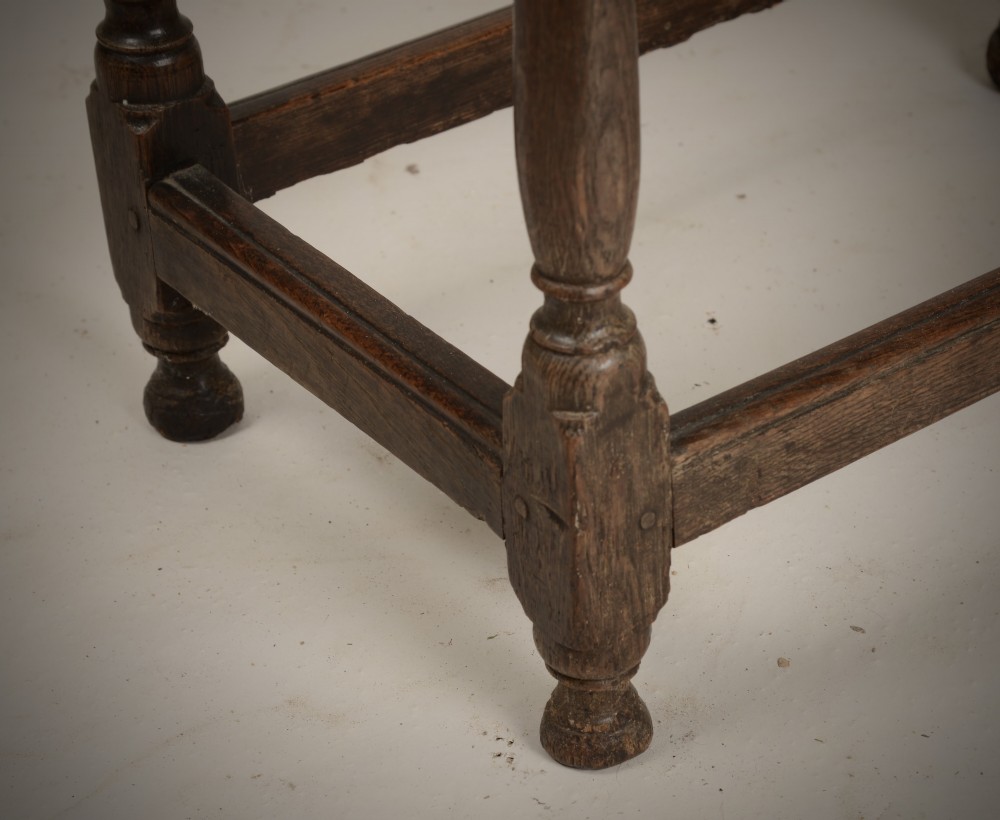 An early 18th-century dark oak tavern table featuring a rectangular plank top, turned legs, and a low box stretcher. View IV