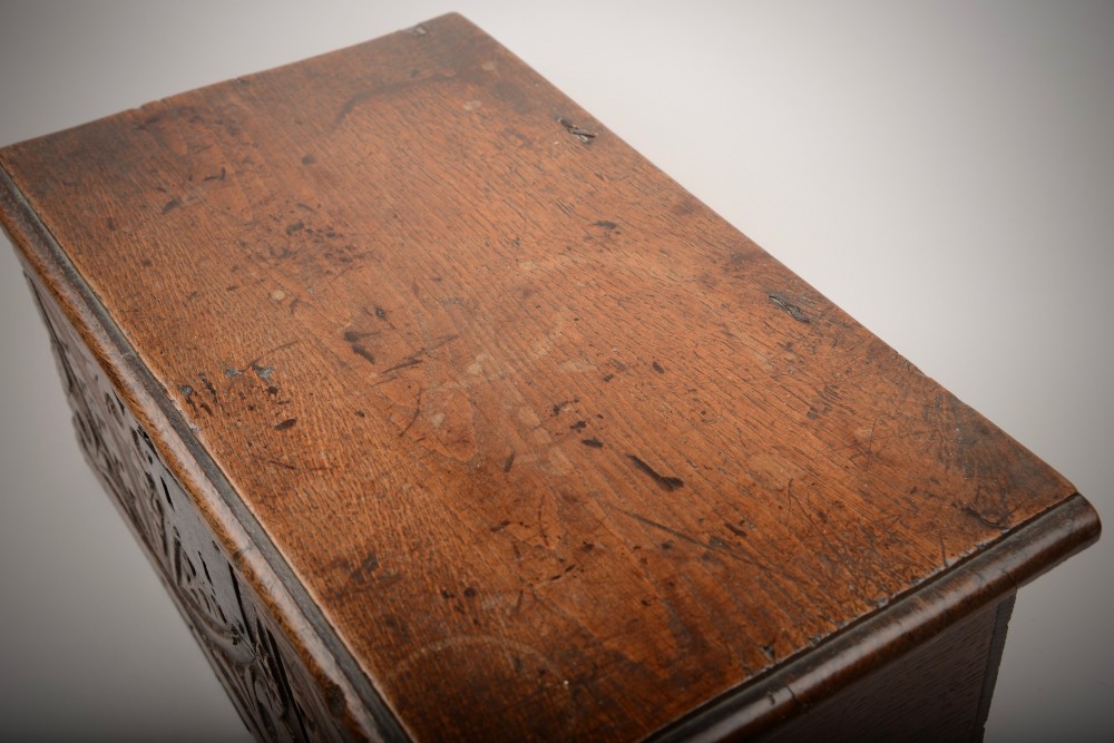 A seventeenth-century dark oak table box with relief-carved leaf and botanical scrollwork on the front panel and a central iron escutcheon plate. View IV