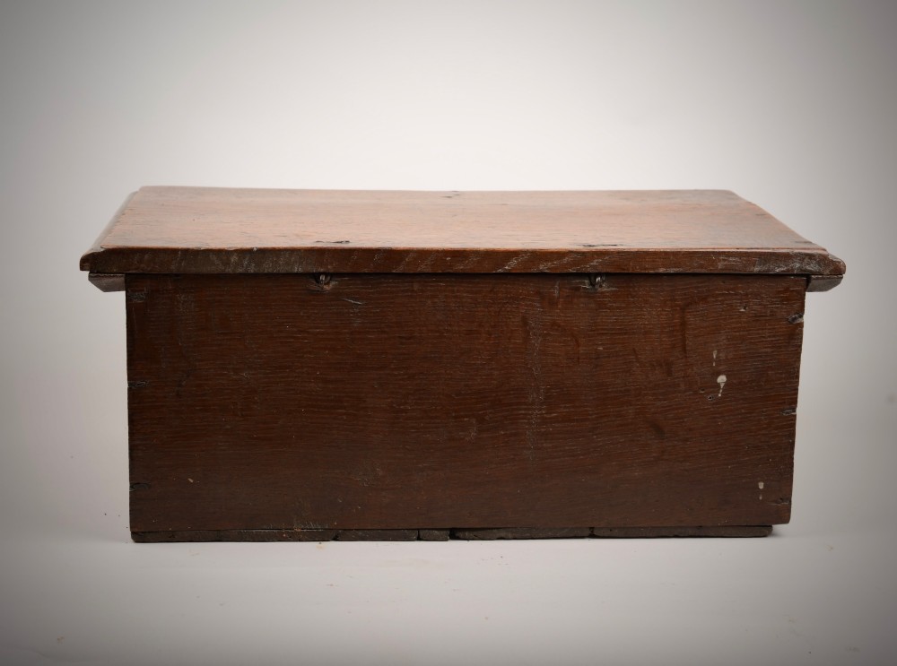 A seventeenth-century dark oak table box with relief-carved leaf and botanical scrollwork on the front panel and a central iron escutcheon plate. View V