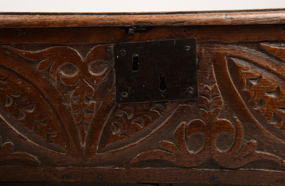 A seventeenth-century dark oak table box with relief-carved leaf and botanical scrollwork on the front panel and a central iron escutcheon plate. View VII