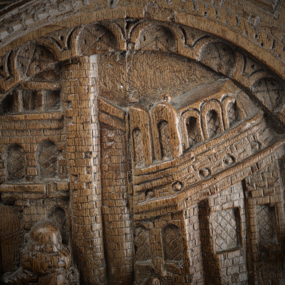 A sixteenth-century rectangular carved oak relief panel depicting a standing soldier with a staff addressing a kneeling figure within an arched architectural backdrop. View IV